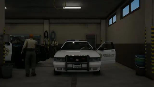 Two-bay station garage with sheriff cruisers and wash-down hoses inside the Sandy Shores MLO